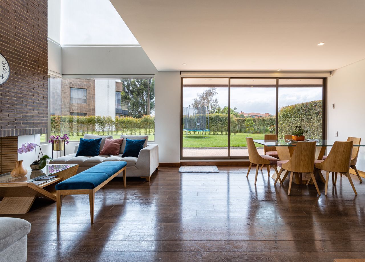 Spacious living room with modern decor and large windows showcasing a garden view.