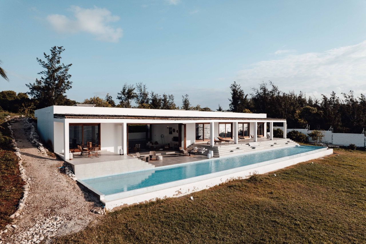 Elegant villa with an infinity pool set in a serene outdoor landscape.