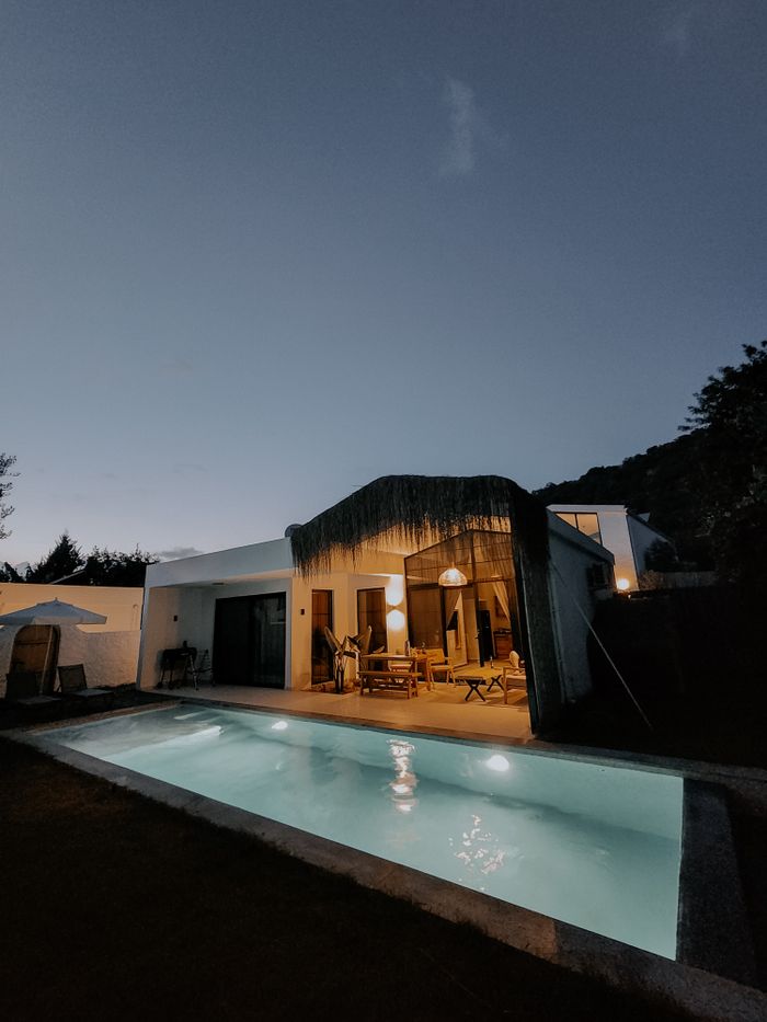 Beautiful villa with pool illuminated at twilight in Kayaköy, Türkiye, offering a serene vacation spot.